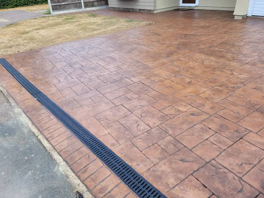 Terracotta imprinted concrete driveway with drainage channel
